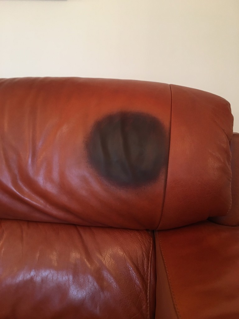 Dark stain on head rest of leather sofa